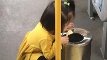 2岁女童蹲在垃圾筒边吃